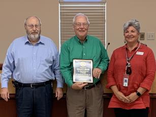 Gilmer County Post 1 Commissioner Dallas Miller (center) receives a plaque for his service at his last meeting on Sept. 12, from Chairman Charlie Paris and Post 2 Commissioner Karleen Ferguson. Miller’s resignation from the board was effective Sept. 13.