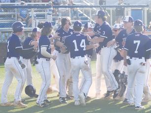 Gilmer baseball players gather around teammate Noah Gutillo following his two-run home run in the seventh inning last Tuesday versus Ringgold. It gave the Bobcats the runs needed for their 4-2 game one victory to begin the state playoffs.