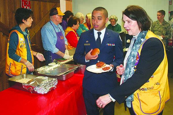 Lion Merle Howell Naylor helps a young cadet from Marietta’s Wheeler High School JROTC program during the annual Veterans Day lunch at the Lions Club.
