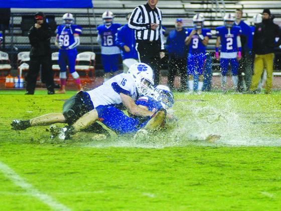 Gilmer’s Braden Jenkins (16) brings down Bruin quarterback Owen Brooker for a splash landing last Friday.