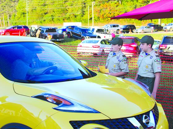 Bryson Petkus, left, and Clay McConnell, both age 11, take up parking donations at the Apple Festival fairgrounds Saturday morning that will help fund Troop 402 programs throughout the year.