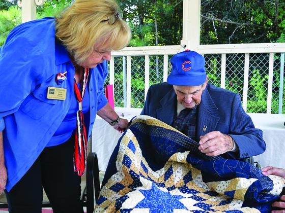 World War II veteran Clyde Mullinax, right, receives a special Quilt of Valor from Lynda Petty Duke, leader of the nonprofit veteran appreciation group’s Dahlonega chapter.