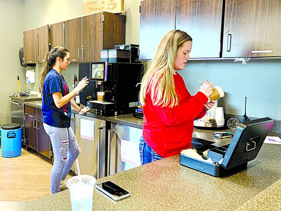 Sabrina Tran (left) brews coffee, and Mary Lambert takes orders at Bobcat Brews in the GHS Media Center.