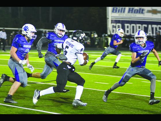 From left, Gilmer High defenders Kyle Allison (2), Cameron Weaver (90) and Donnie Ledford (4) corral Ridgeland’s Terrance Roberts last Friday. The Bobcat trio combined for 31 total tackles.