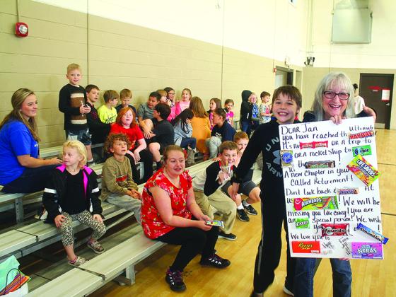 Jan Day, right, holds a sweet gift from kids at the Three Rivers Boys and Girls Club while being congratulated on her retirement by Seth Turner, left, during a special snack time at the club.