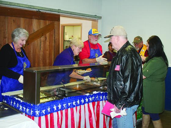 Ellijay Lions Bonnie Dixon, Susan Harden and Charlie Dixon serve barbecue and fixings to appreciative attendees.