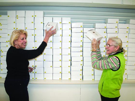 Denise Sewczwicz and Glen Peaden share a laugh while stacking boxes for customers to use during last year’s Christmas Cookie Walk at Good Samaritan Catholic Church.