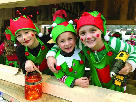 The elves were busy working in Santa’s float in the Light Up Ellijay parade Nov. 29. 5 year old Ryan Ehrmann, center, is being hugged by Jordan, an experienced 10 year old elf, as another adorable elf pauses for the camera. Shared on Facebook by Lisa Ehrmann.