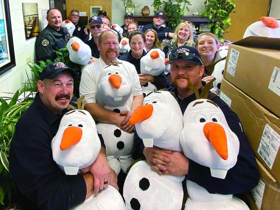 Employees of Gilmer County Fire and Rescue and the Ellijay Fire Department deliver a family of Olafs and other Christmas toys to staff at Mountain View Elementary School. 