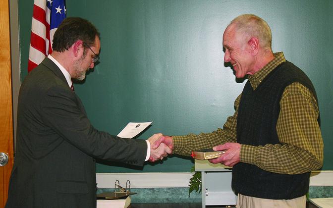 Judge Scott Chastain, left, shakes hands with Al Hoyle after Hoyle was sworn in for a new term as Mayor of Ellijay.