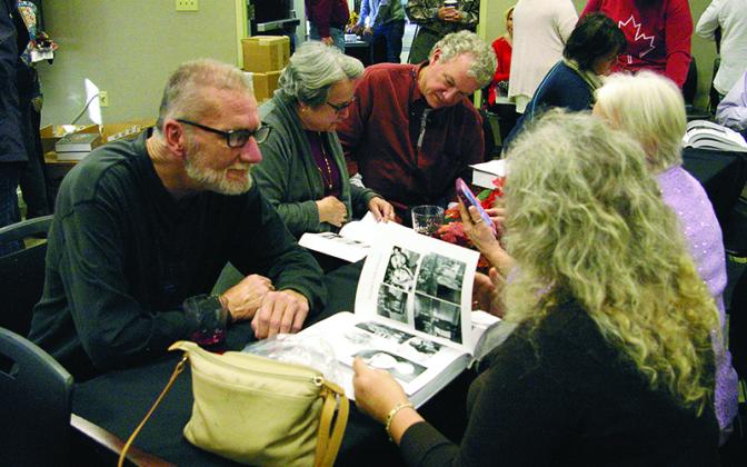 Attendees get a first look at Faces of Our Ancestors: First Families of Gilmer County Georgia during a book release party at the Gilmer County Library last December. Below, the front cover of the over 800-page book.