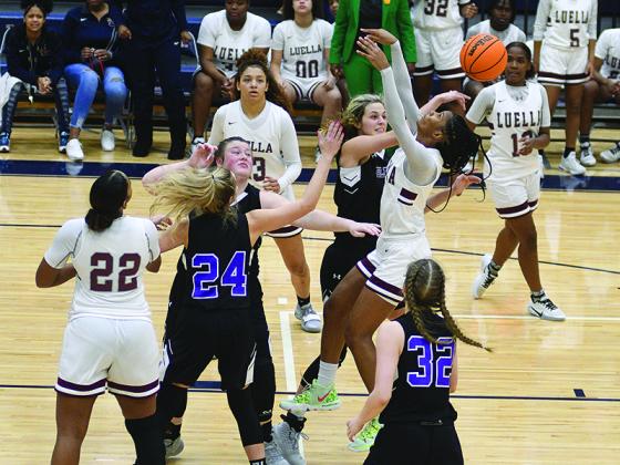 Gilmer’s Elly Callihan tallies one of her four blocks as she rejects Luella’s Keely Brown last Wednesday as teammates Jalynn Ledford and Emma Callihan (24) help defend the post.