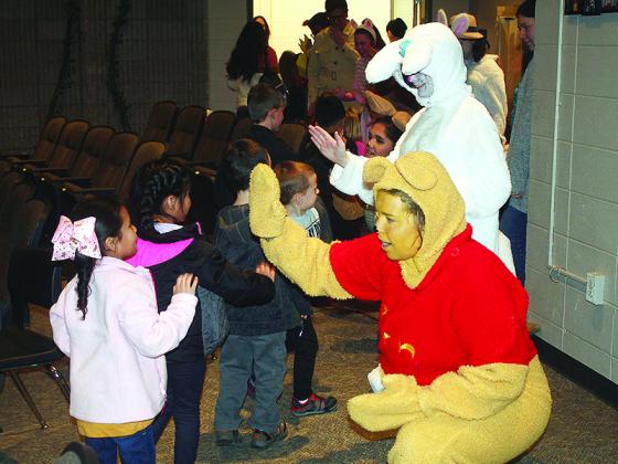 Raegan Dempsey (as Winnie the Pooh), Jasmine Douglass (as Late Rabbit) and other characters from the Hundred Acre Wood give high fives and hugs to visiting pre-K and kindergarten students following a special presentation of Gilmer High School Theatre’s winter production, The House at Pooh Corner, last week.