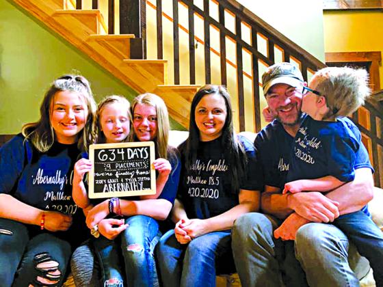 The “new” Abernathy family includes, from left, Chassady, Zoey, Emma, Beverley, Barry and Tyler. Father and son each share the exact same birth defect on their left hands, and the elder bluegrass picker is teaching his adopted progeny how to play.