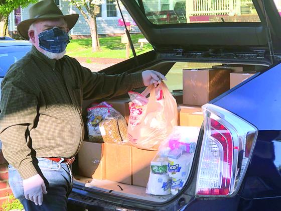 At the Gilmer Senior Center, Robert Gregory, top, and Janice Melvin, below, load meals and special goody bags for local Meals on Wheels recipients.