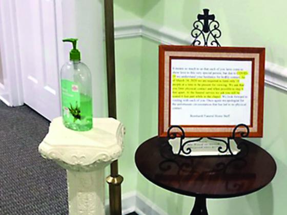 Signs posted at Bernhardt Funeral Home notify those attending funerals or visitations at either establishment to limit physical contact and maintain distancing of at least six feet.