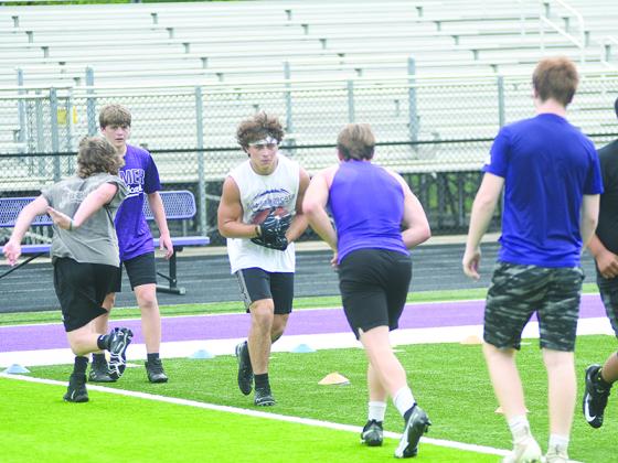 Gilmer running backs work on hand offs and ball handling during a conditioning session earlier this summer.