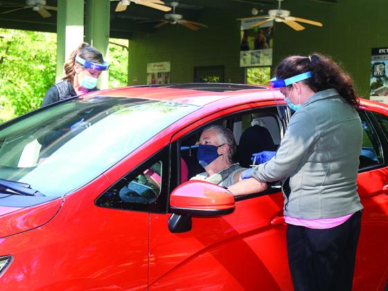 Gilmer Health Department nurses Krystal Sumner, left, and Jennifer Vick vaccinate patients at the health department’s drive-thru flu shot clinic last Tuesday.