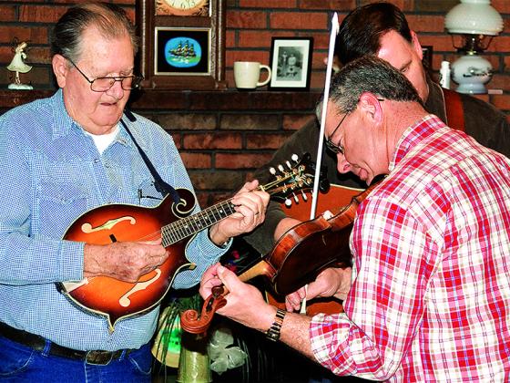 Chancey, left, picks the mandolin alongside bandmates Wayne Wright, in back, and Jerry Hensley, right, during a get-together at his home in 2010.