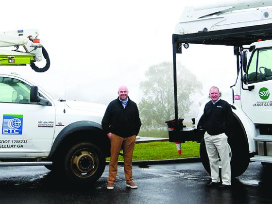 Pictured beside service trucks of their respective companies are ETC Chief Operating Officer Jason Smith, left, and Amicalola EMC President and CEO Todd Payne.