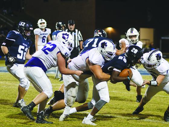 Gilmer’s Tyler Gatlin wraps up West Hall’s Josiah Henriques as Will Bradburn (52) and Seth Darling (8) assist last Friday.