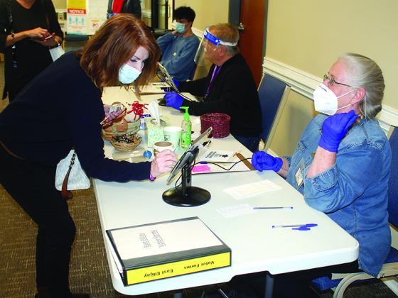 Poll worker Mary Shaw, right, helps voter Lois Leatherwood get signed in during Election Day voting at the East Ellijay (City Hall) polling place.