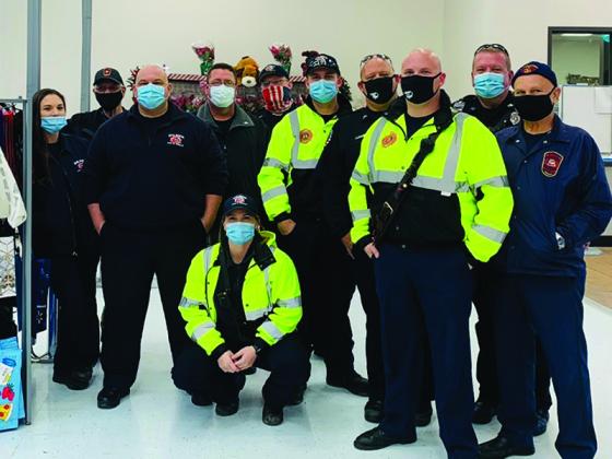 Employees of Gilmer County Public Safety and the Ellijay Fire Department team up to shop for toys at the East Ellijay Walmart. Pictured, from left: Montana Tincher, Al Cash, Aaron Freeman, Keith Kucera, Marshall Rhodes, Katie Deperro (kneeling), Max Gunn, Mike Williams, C.J. Morris, Sean Banks and Gary Watkins. 