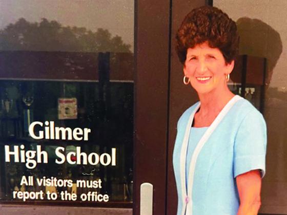 Ruth Caudell is pictured at the front entrance of Gilmer High School, where she taught and later worked as an administrator from 1962-2000.