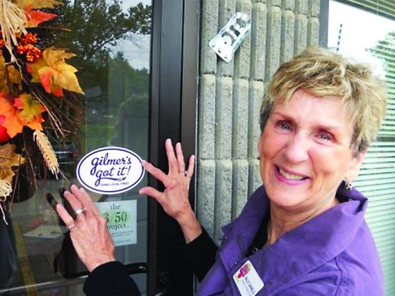 Sally Daniels puts a “Gilmer’s Got It” sticker on the Gilmer Chamber’s door following the launch of the 2010s shop local campaign, which was Daniels’ idea. 