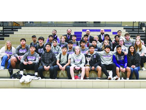 Gilmer High School wrestlers, coaches and managers gather around the Bobcats’ runner-up trophy from the Class 3A state duals last Saturday. Gilmer has reached the duals state finals in 12 consecutive seasons, and its latest runner-up placement was its fifth in a row.