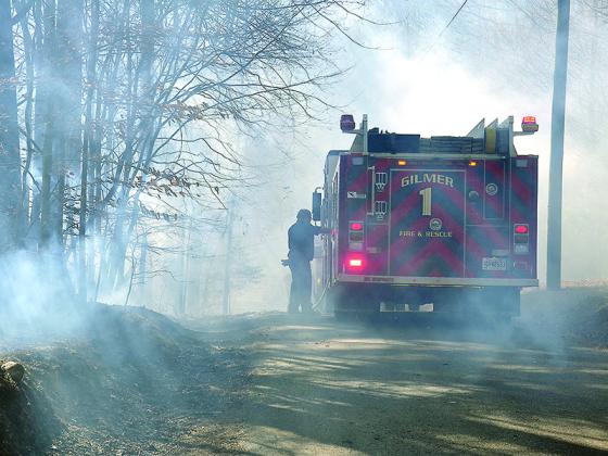 Firefighter Jason Ware is silhouetted in heavy smoke as Gilmer Fire and Rescue responds to one of several recent brush fires.