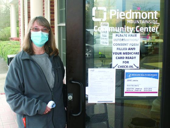 Trina Matthews, of the Gilmer County Health Department, opens the door for a round of morning COVID-19 vaccinations to begin at the Piedmont Mountainside Community Center clinic site.