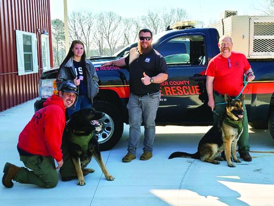 Gilmer Fire and Rescue employees Mikey Bramlett, left, with search dog, Duke, and Mike Dempsey, right, with search dog, Axel, are pictured with trail layer Nicole Linton and instructor Shayne Schettler, of Georgia K9 National Training Center.