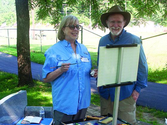 During a past Plein Air, Art in the Mountains weekend, artists Ann and Larry Hall look at one of Ann’s paintings-in-progress at River Park.