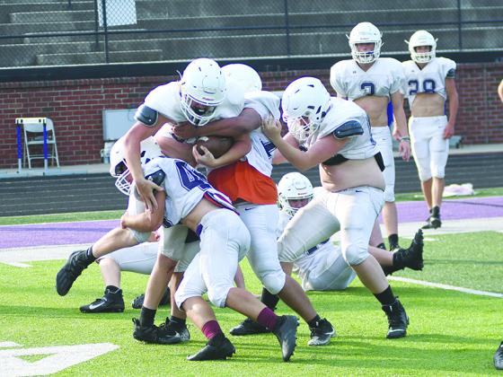 Gilmer High School football players take part in an Oklahoma drill to end spring practice last Wednesday, which pits offensive linemen and a running back against defensive linemen and a linebacker.