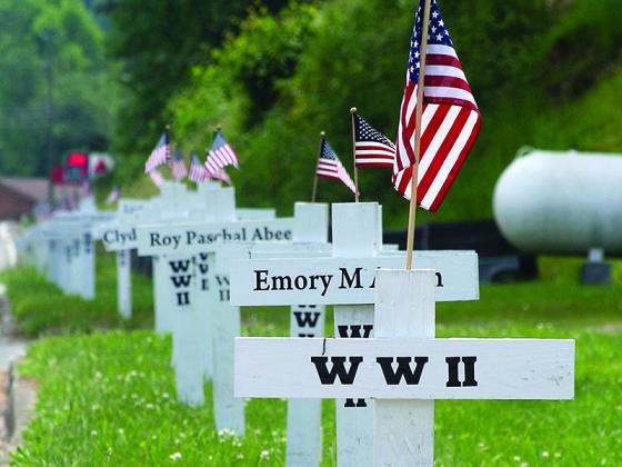 Pictured is the beginning of a line of white wooden crosses now displayed along South Main Street in recognition of Memorial Day. Each marker bears the name of a deceased Gilmer County veteran. Different branches of Ellijay American Legion Post 82 typically put up more than 1,000 of the crosses twice a year in observance of Memorial Day and Veterans Day. 