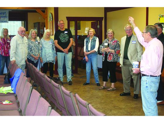 Gilmer Community Food Pantry Director Allen Triebel, right, welcomes past and present volunteers to a 20th anniversary reception held at the food pantry Monday, May 3.  