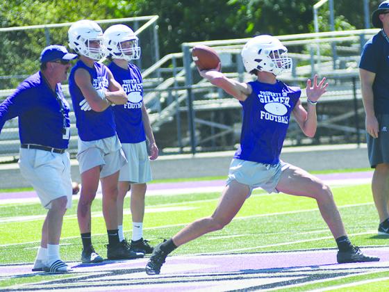 Gilmer football head coach Paul Standard (left) looks on as quarterback Seth Darling passes downfield versus Fellowship Christian last Thursday.