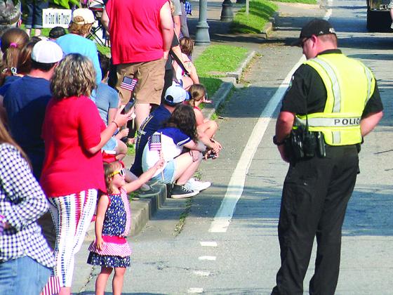 A patriotic little girl waves her flag at one of City of Ellijay's finest.