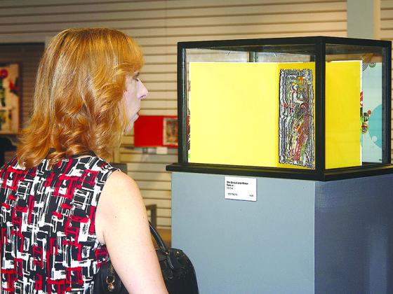 Julia Parker gets an up-close look at the fine details in one of Ted Wray’s book sculptures displayed at the Gilmer Arts Gallery. 