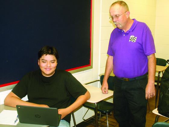 Student Ismael Garcia-Landaverde, left, completes an assignment under the instruction of Gilmer High School Auto Tech teacher Ken Martin. 