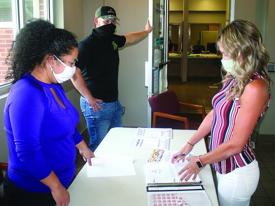 Maria Rodriguez, left, and Garrett Ralston, center, both of Pilgrim’s Ellijay, prepare registration information with Ashley Rice, of the Gilmer Health Department, right, during a COVID-19 vaccination clinic Tuesday, Aug. 10. Those who came to the health department to get their first COVID shot that day were entered into a prize drawing to win a year’s supply of meat courtesy of the local Pilgrim’s plant. 