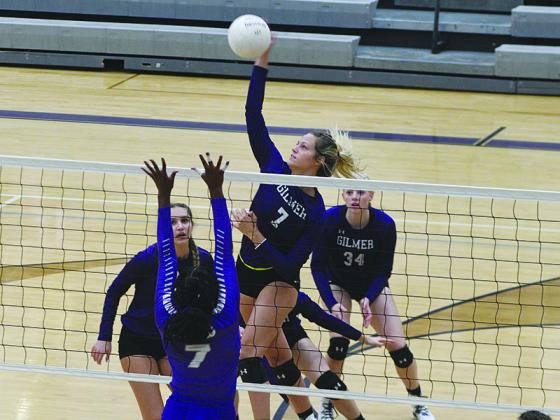 Gilmer senior hitter Elly Callihan (7) plays a ball at the net as teammates, from left, Anneliese Vaughn and Taylor McCormick get in position.