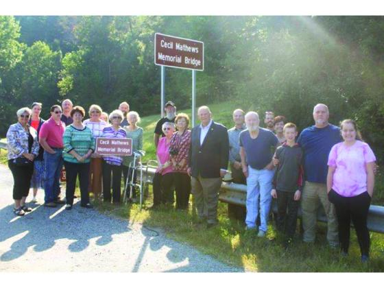 Family of the late Cecil Mathews are joined by Georgia House Speaker David Ralston, center, Gilmer Post Two Commissioner Karleen Ferguson, left, and Gilmer Chamber president Jennifer Grimmer, second from left, for a dedication of the bridge over Turniptown Creek now named in memory of Mathews. 
