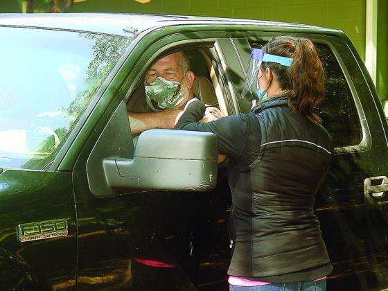 Krystal Sumner, Gilmer Health Department nurse manager, preps a patient during last year’s drive-thru flu shot clinic. 