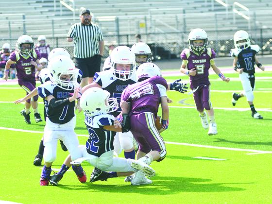Bobcat Lance West (22) tackles a Dawson County running back as teammates Colton Purdy (7) and Jack Eller (55) assist last Saturday.