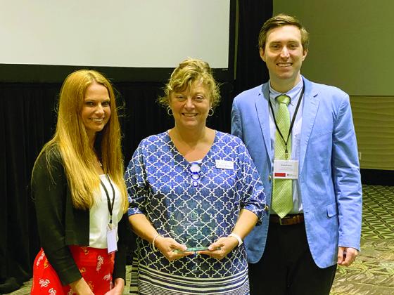 Gilmer County Chief Registrar Tammy Watkins, center, receives the Frances Duncan Award from Leigh Combs, state elections liaison, left, and state Elections Director Blake Evans, right, at the recent Georgia Association of Voter Registration and Election Officials Conference.