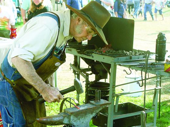 Blacksmith  John Zeigler, of Murphy, N.C., strikes while the iron is hot.