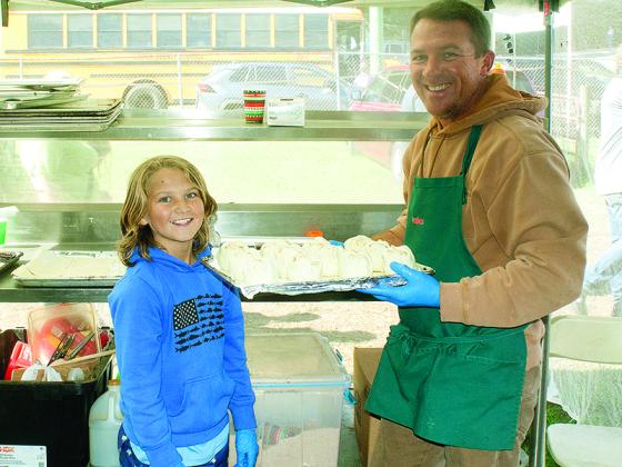 Ken Moulder, right, and son, Jackson, of Concord, get ready to put a pan of freshly made apple dumplings in the oven.