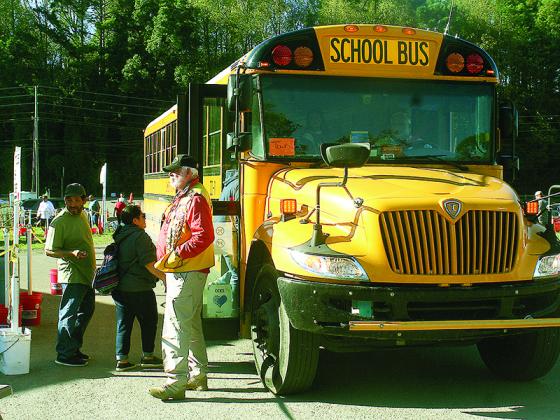 A shuttle bus loads at festival’s north entrance under the supervision of Ellijay Lion Ben Arp.
